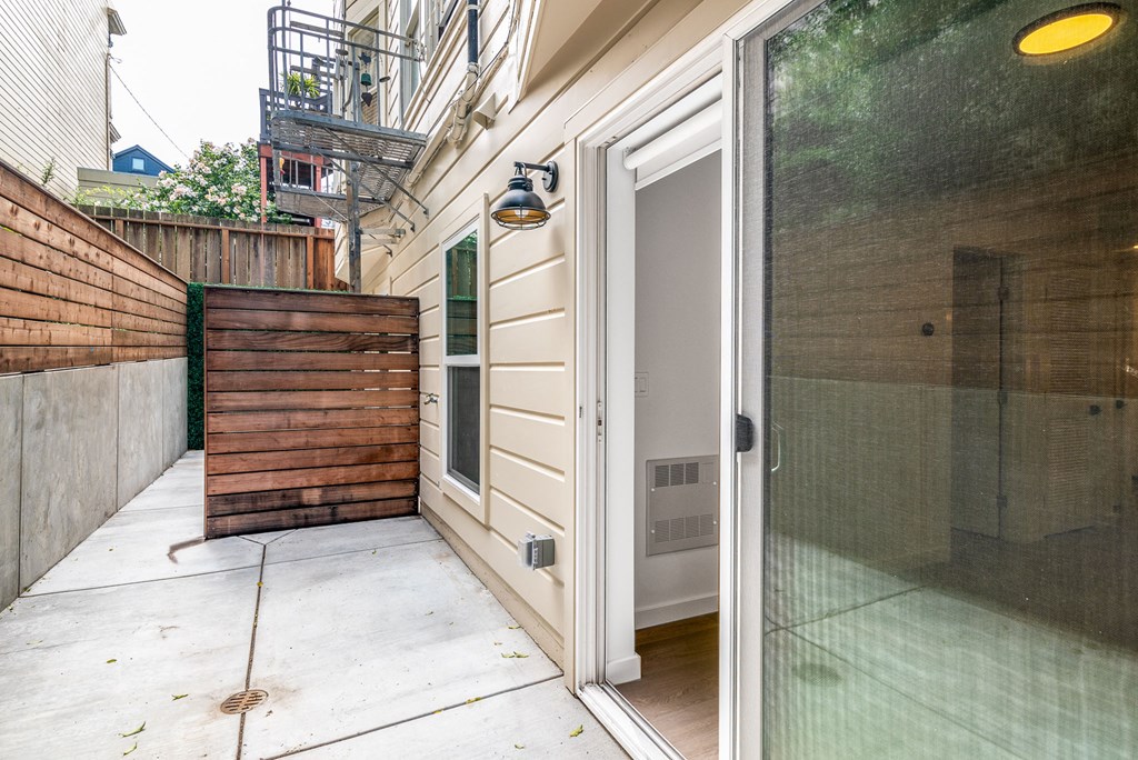 a patio with a white door and a wooden fence