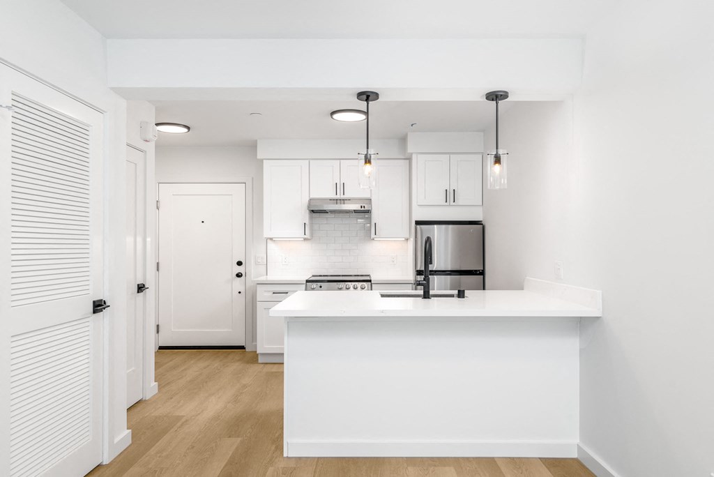 a kitchen with white cabinets and a white counter top
