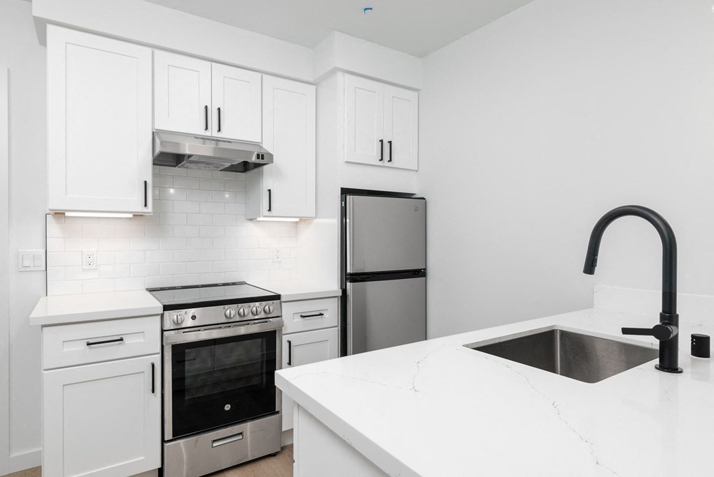 a kitchen with white cabinets and stainless steel appliances