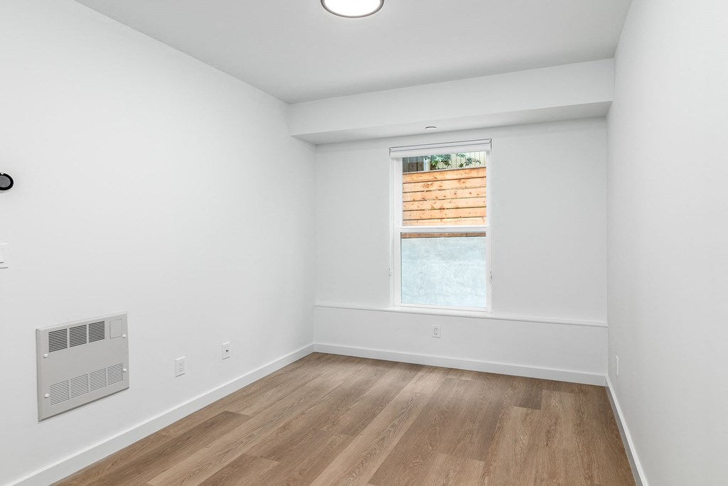 an empty room with white walls and a window