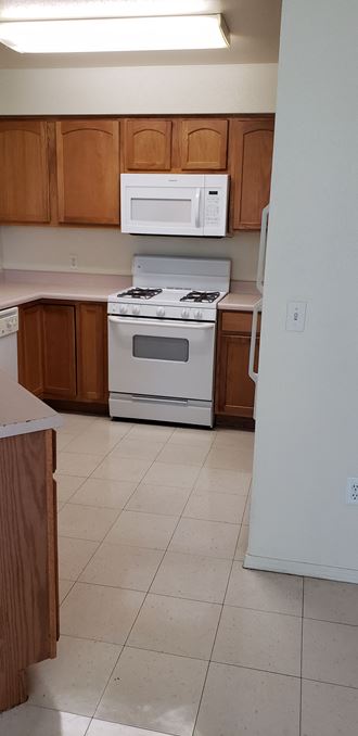 Image of stove, dishwasher, refrigerator, microwave, cabinets, and counter