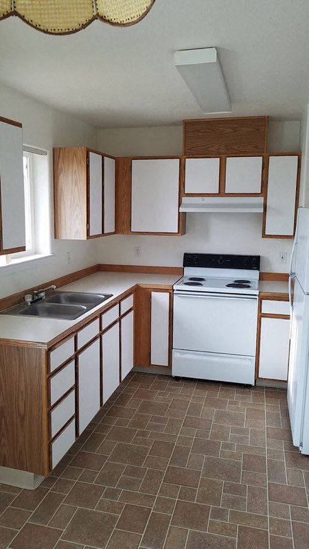 an empty kitchen with a stove and a sink