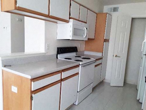 a white kitchen with a stove and a microwave