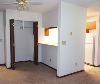 Image of overhead fan, entrance to kitchen, and closet with hanger rack