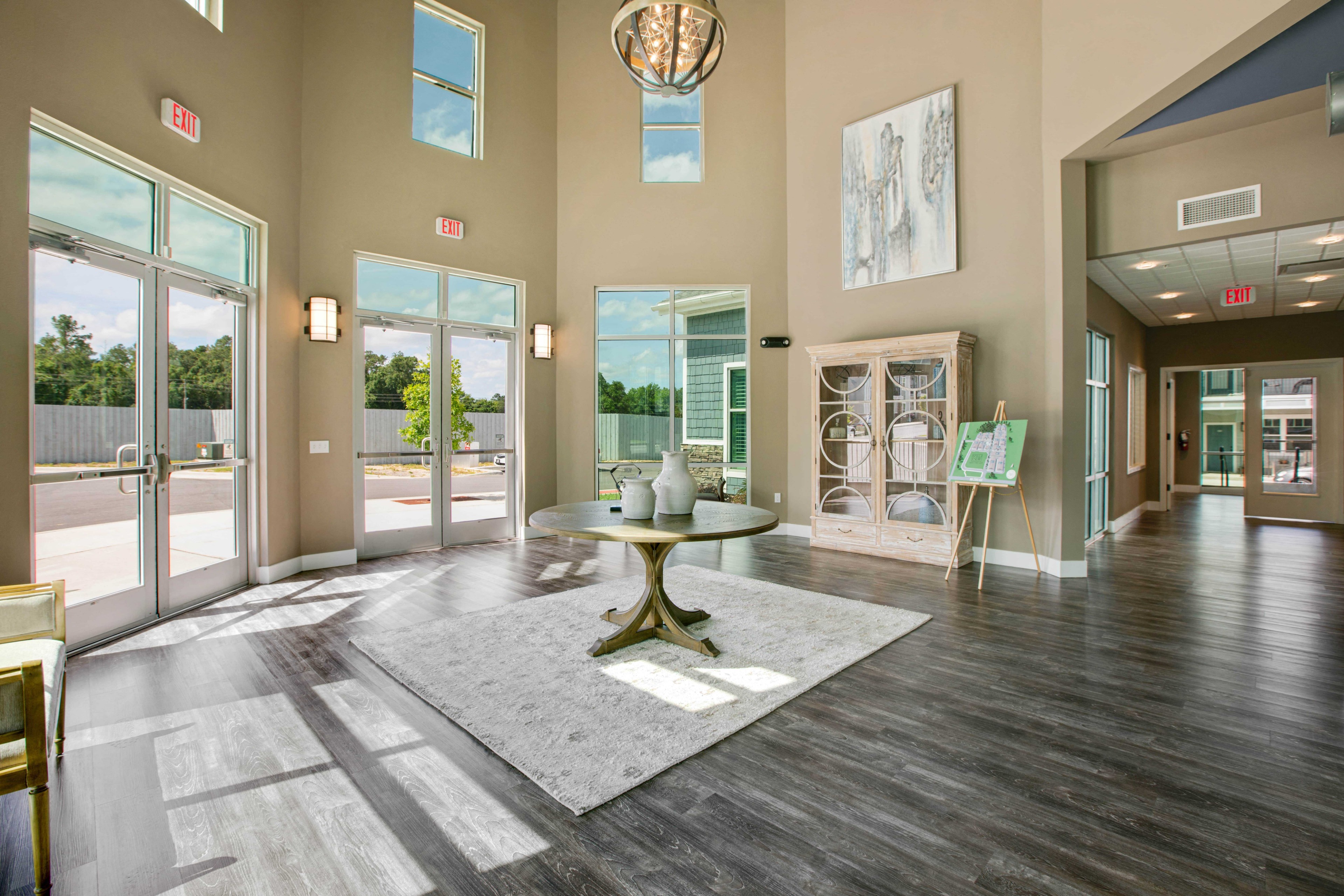 a lobby with a table and a rug and windows