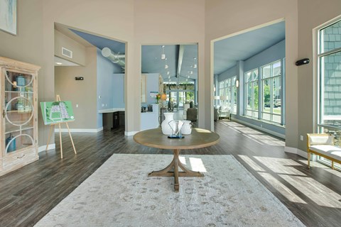 a living room with large windows and a table