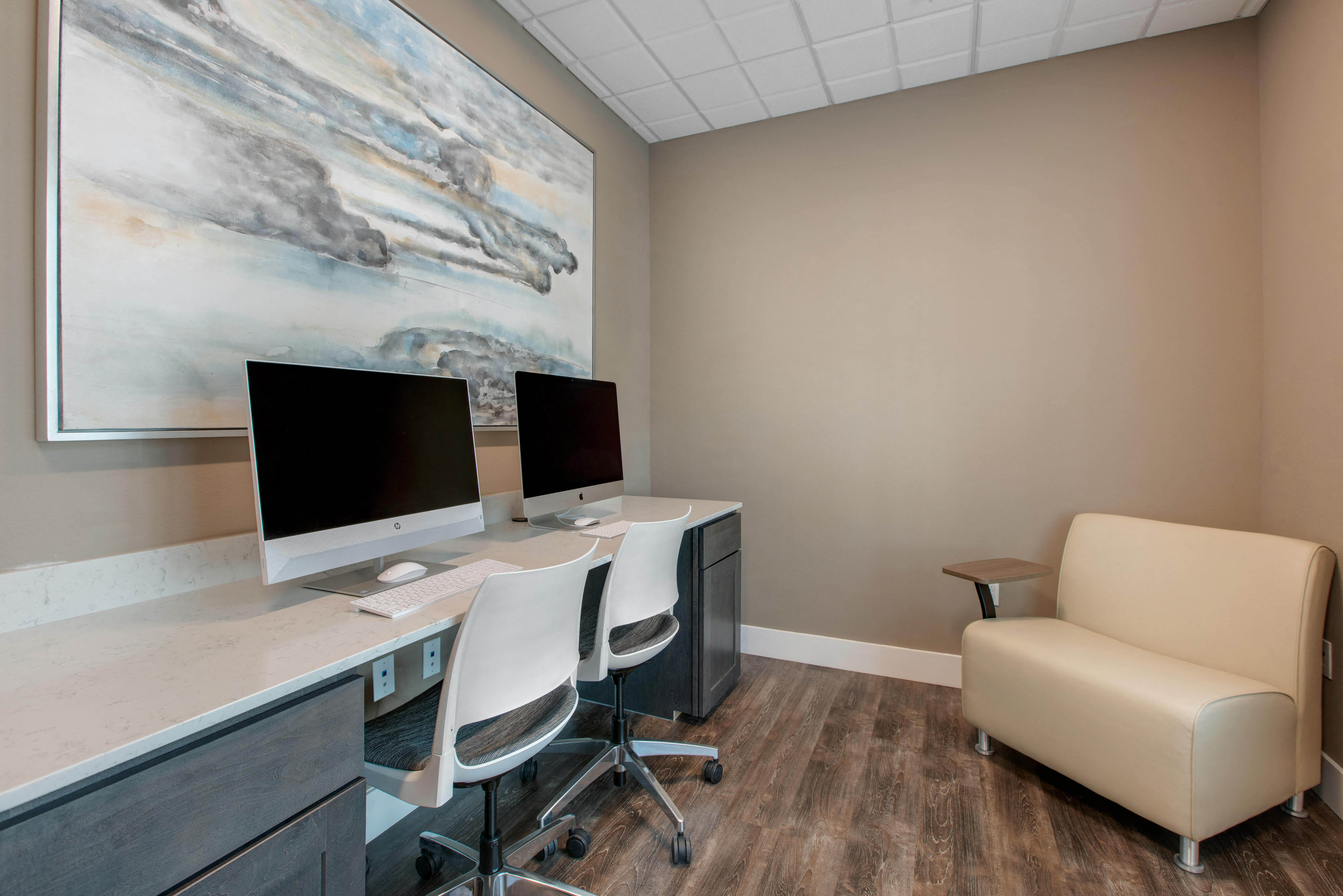 a office with two computer monitors on a desk and a chair