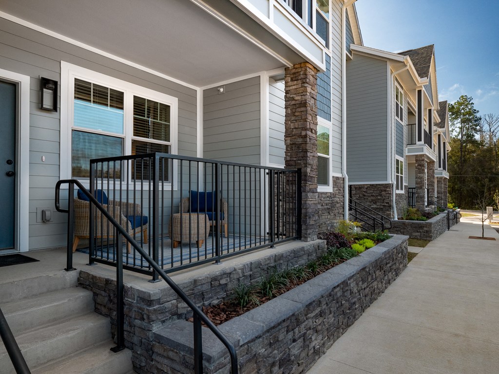 view of the front porch of a home with stairs and a wrought iron fence