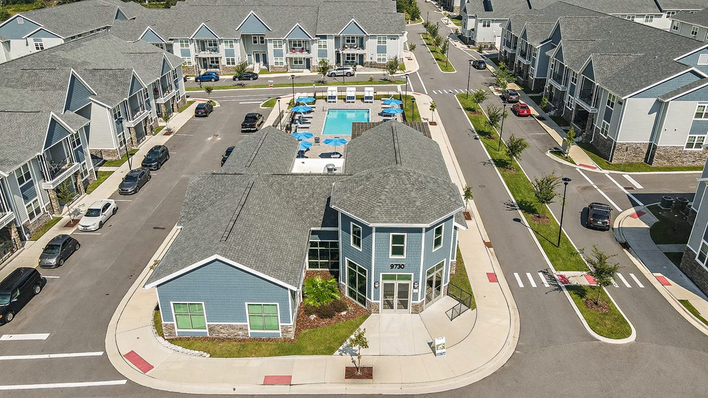 an aerial view of a neighborhood of houses with a swimming pool