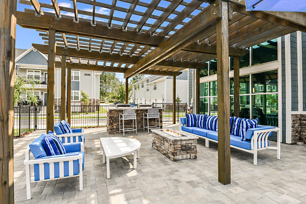a patio with blue chairs and tables and a pergola