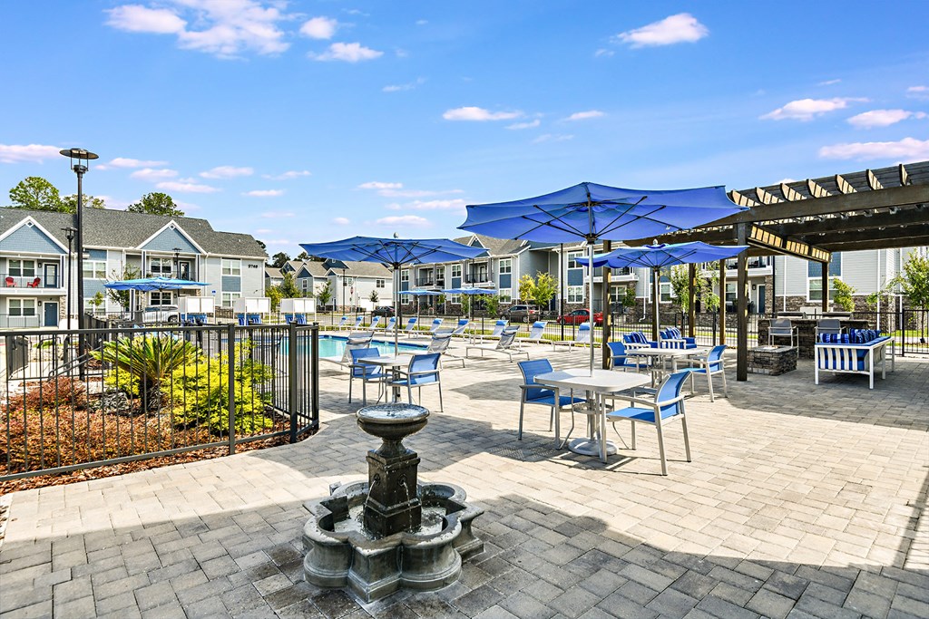 a patio with tables and chairs and umbrellas at the enclave at woodbury