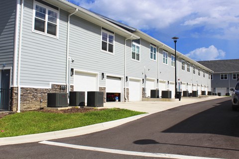 a building with white siding and a street in front of it