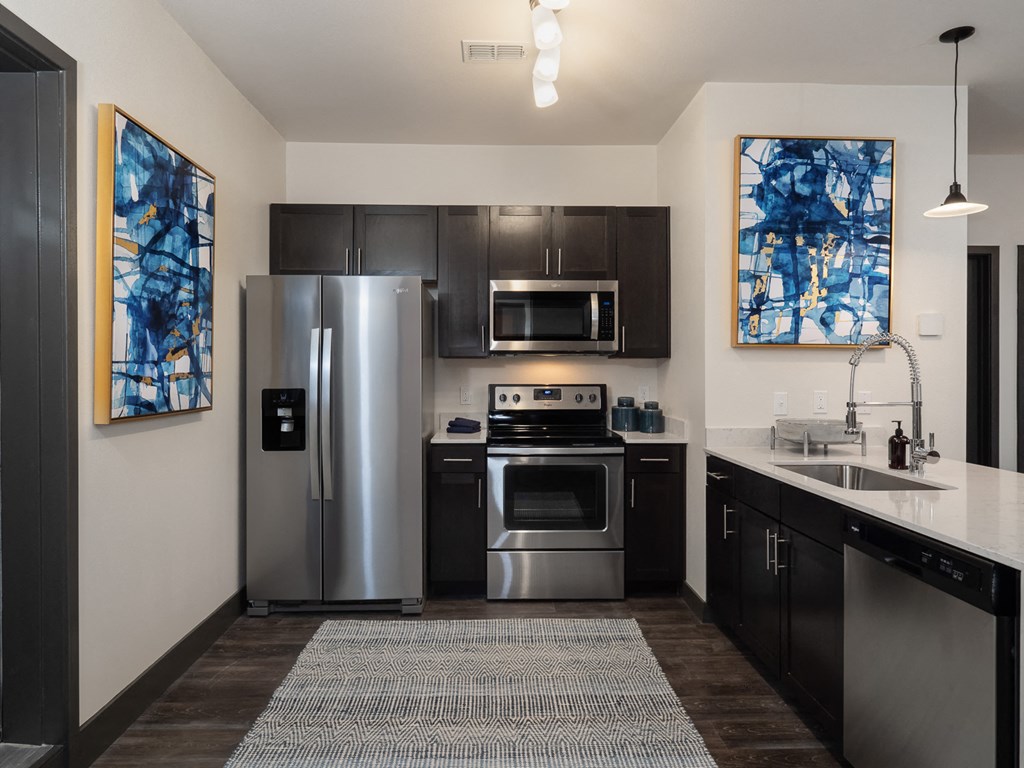 a kitchen with stainless steel appliances and a sink and refrigerator