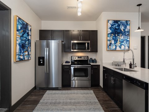 a kitchen with stainless steel appliances and a sink and refrigerator