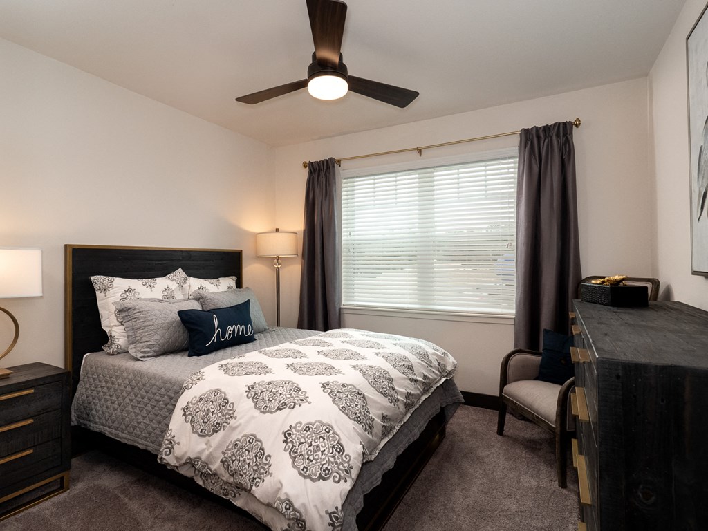 a bedroom with a bed and a ceiling fan
