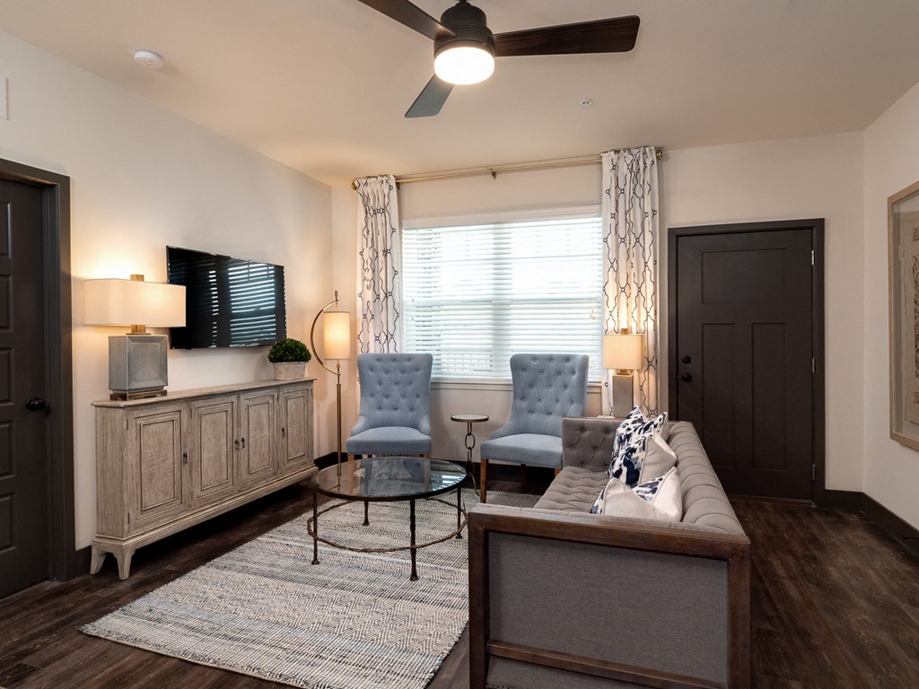 a living room with a couch and chairs and a tv