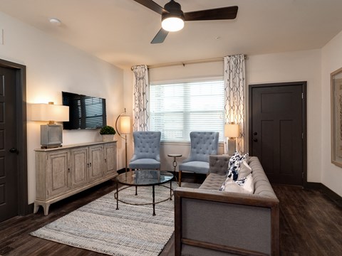 a living room with a couch and chairs and a tv