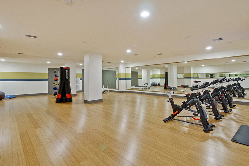 Campbell, CA Apartments - Revere Campbell - Fitness Center with Stationary Bikes, Weight Equipment, and Wall-to-Wall Mirror