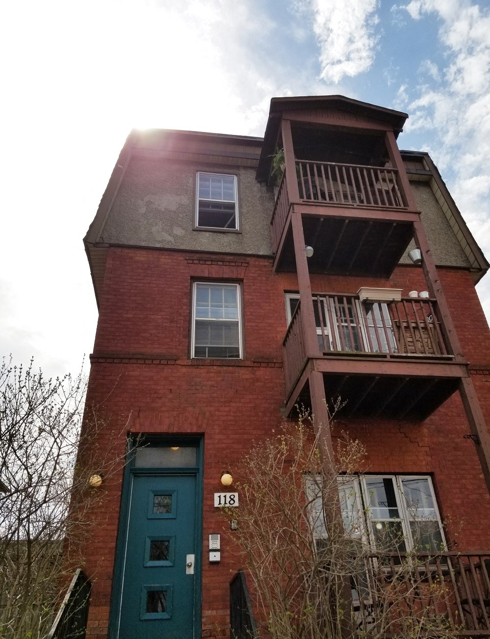 the front of a red brick building with a green door