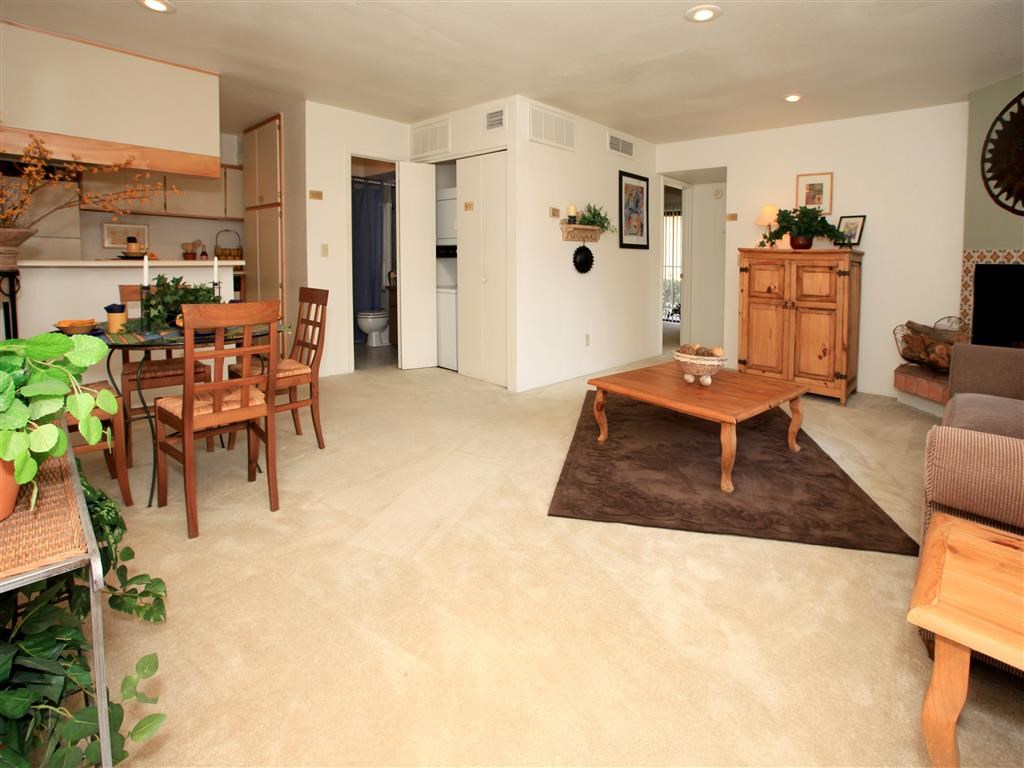 a living room and dining room with a table and chairs