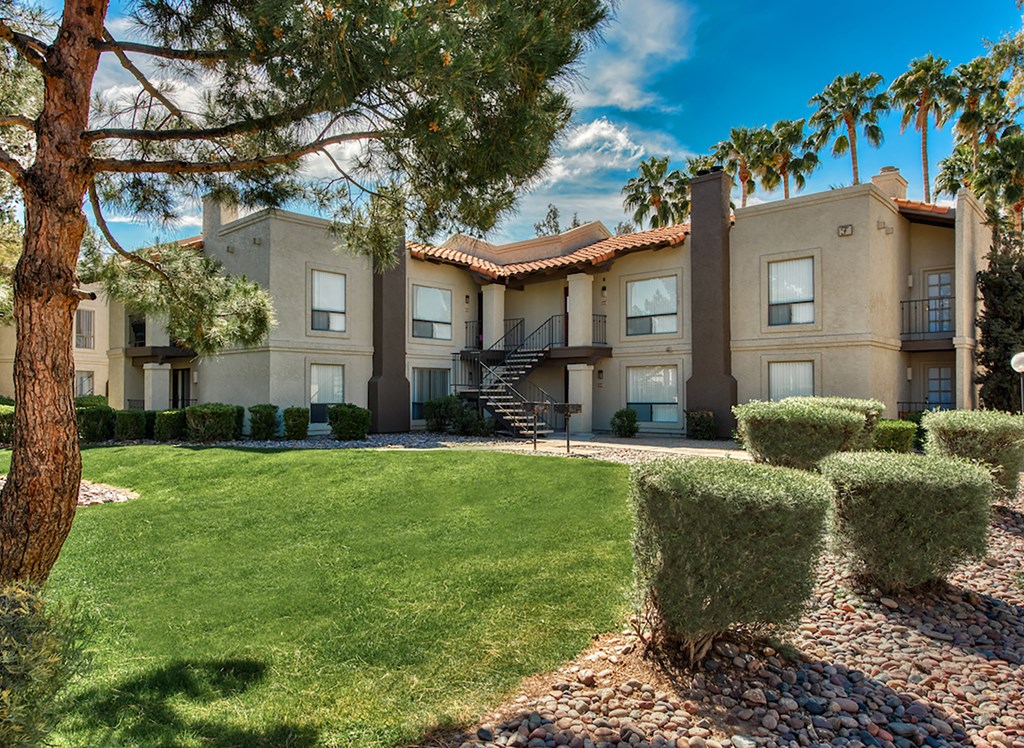 a building with a lawn and trees in front of it