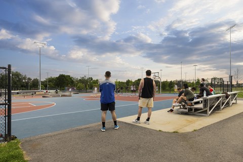 a group of men are standing around a basketball court