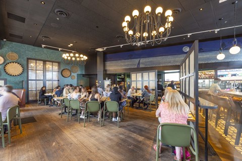 people sitting at tables in a restaurant with a bar