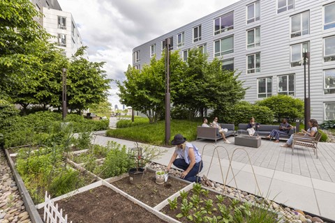 a woman working in a garden in front of a building
