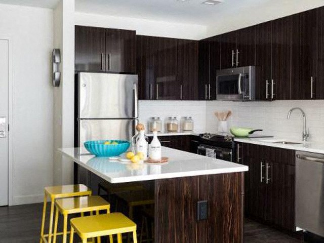 a kitchen with yellow bar stools and a refrigerator