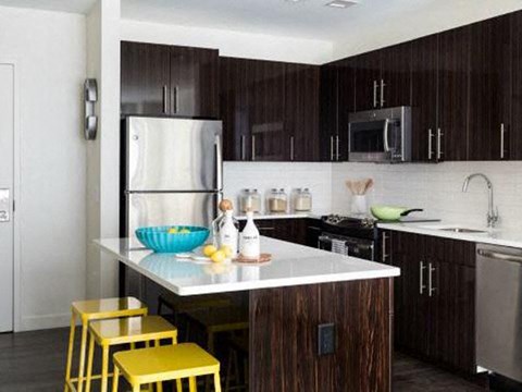 a kitchen with yellow bar stools and a refrigerator