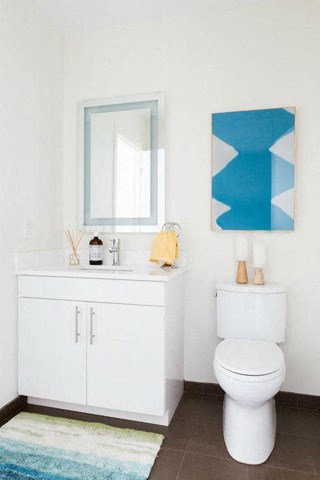 a bathroom with a white toilet and a sink and a mirror