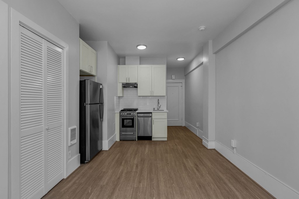 a renovated kitchen with white cabinets and stainless steel appliances