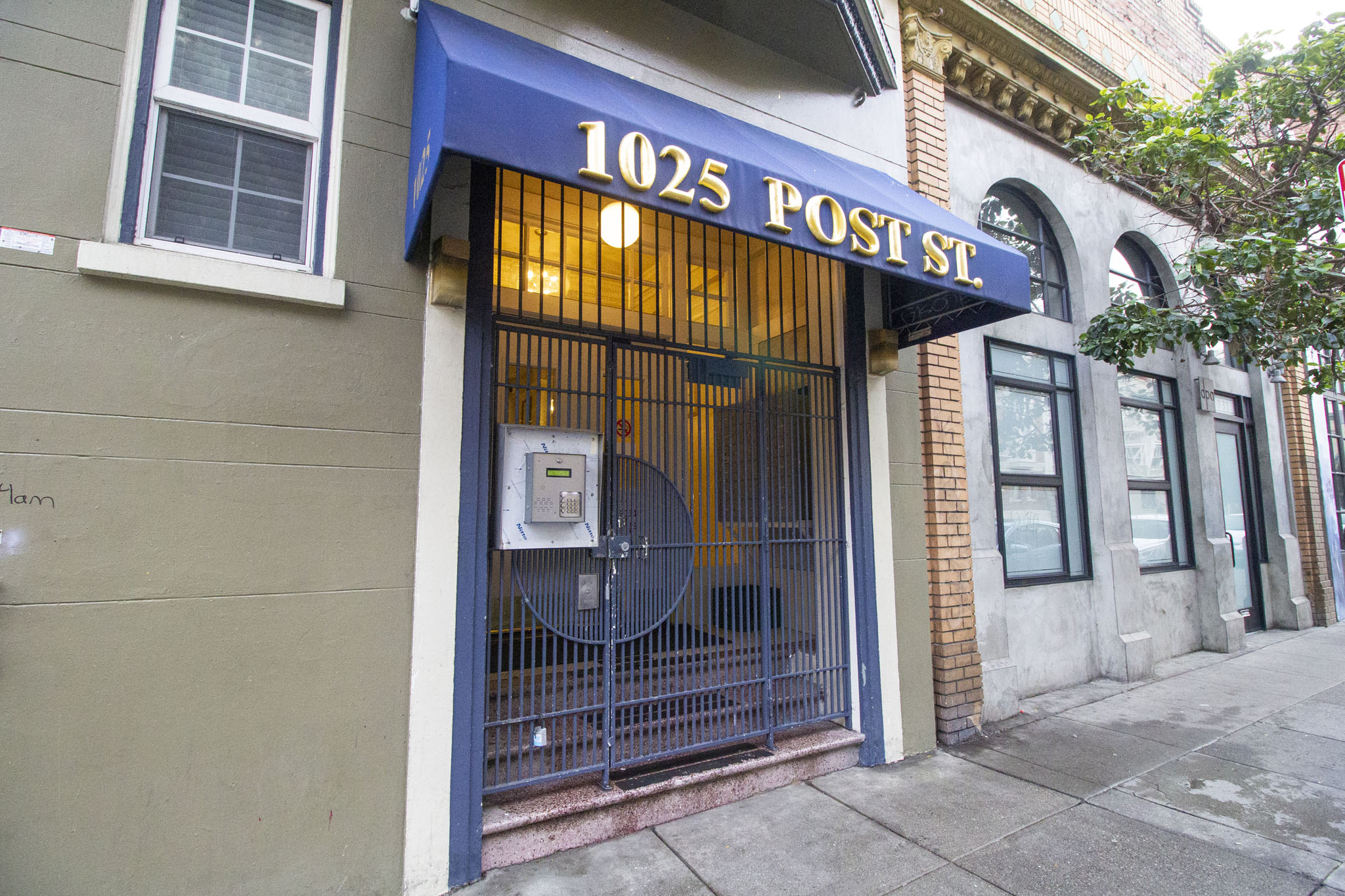 A post office with a blue awning and a sign that reads 1025 POST ST.