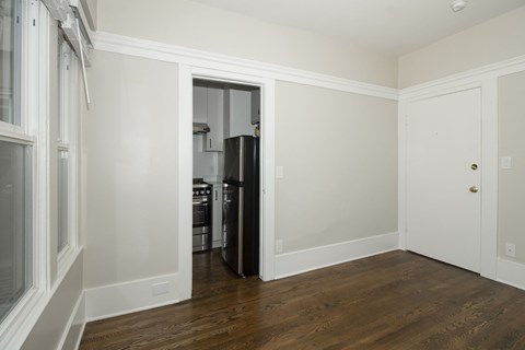 A kitchen with white cabinets and a black refrigerator.