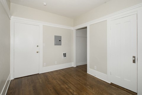 A room with white doors and a wooden floor.