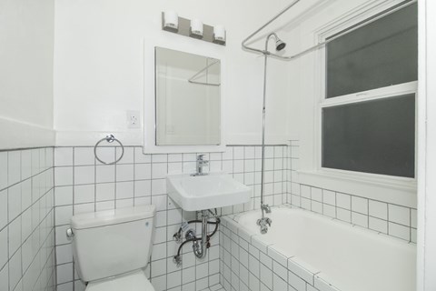 A white bathroom with a toilet, sink, and tub.