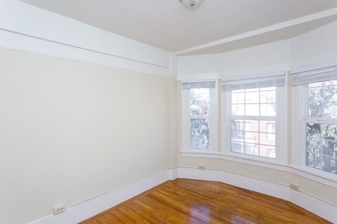 A room with a window and wooden floor.