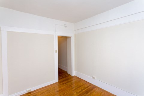 A room with a wooden floor and white walls.
