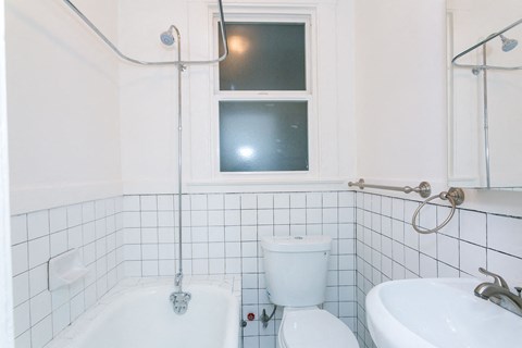 A white bathroom with a toilet, sink, and bathtub.