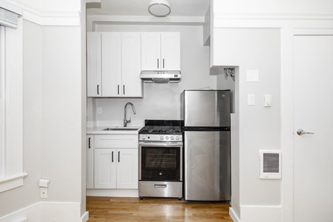 A modern kitchen with a stainless steel refrigerator, oven, and cabinets.