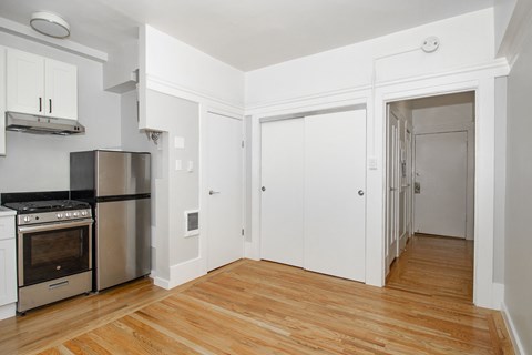 A kitchen with a stove top oven and a refrigerator.
