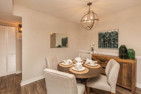 A dining room with a round table set for four.