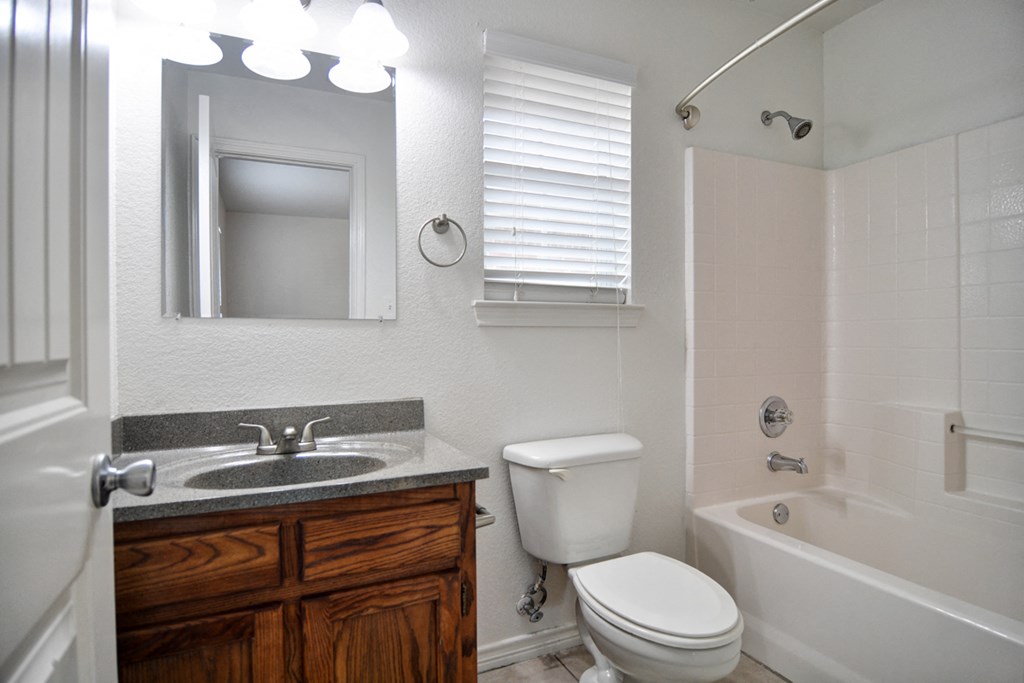 a bathroom with a toilet sink and tub and a mirror
