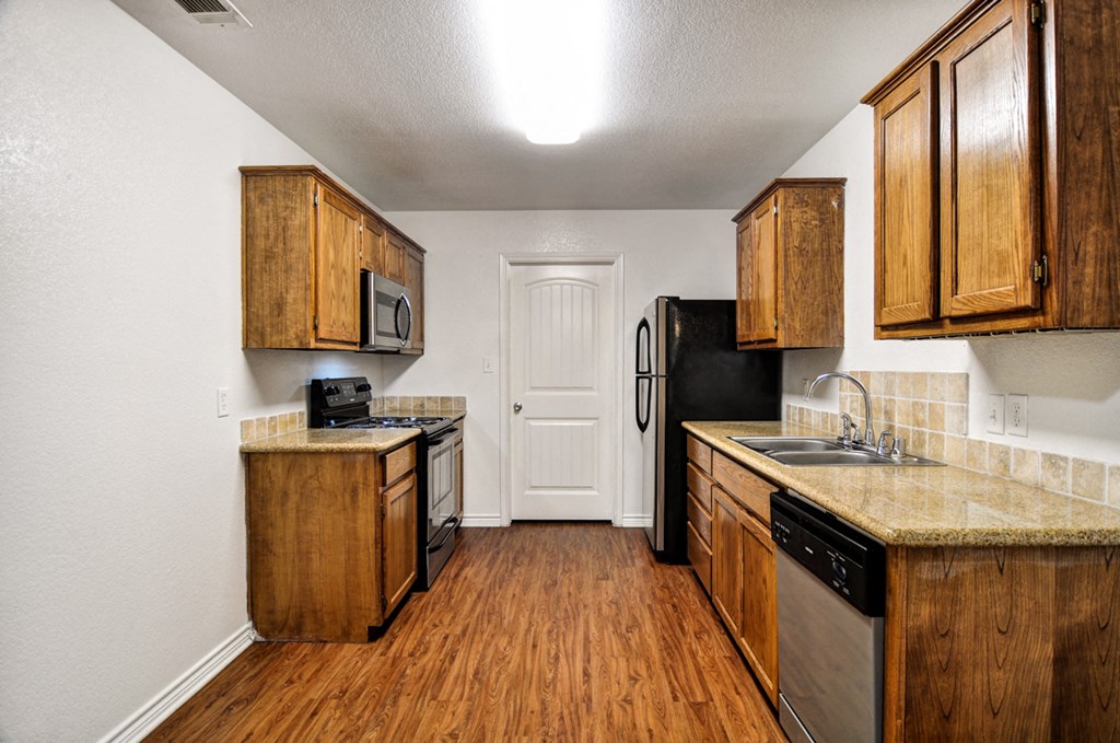 a kitchen with wooden cabinets and a sink and a refrigerator