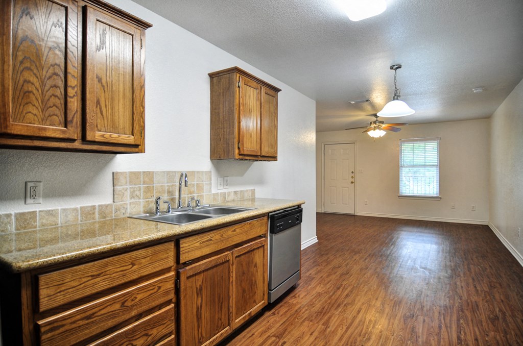 an empty kitchen with wooden cabinets and a sink
