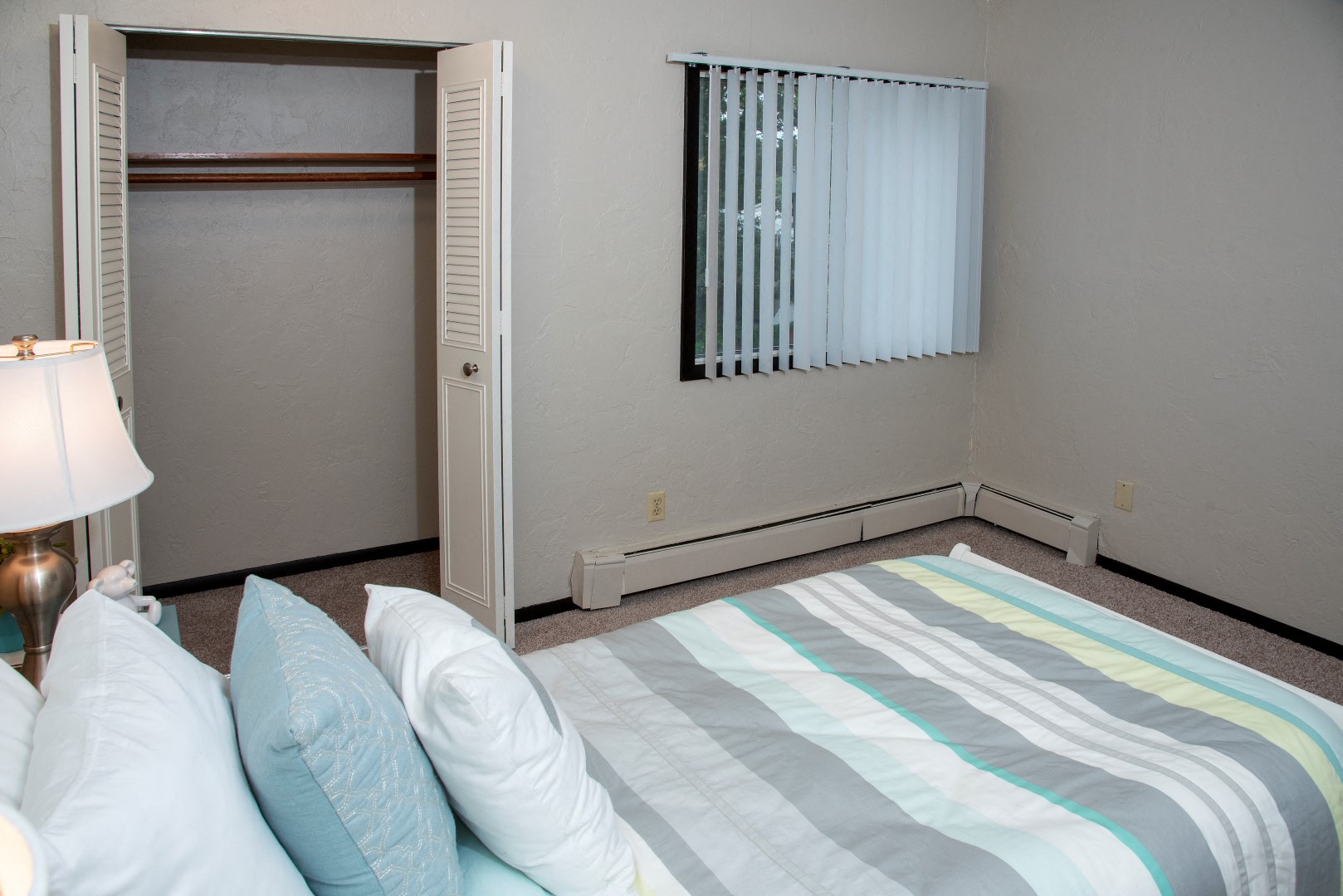 a bedroom with a bed and a window and a closet