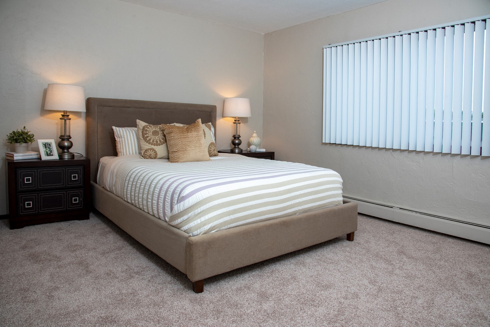a bedroom with a bed and a window with blinds