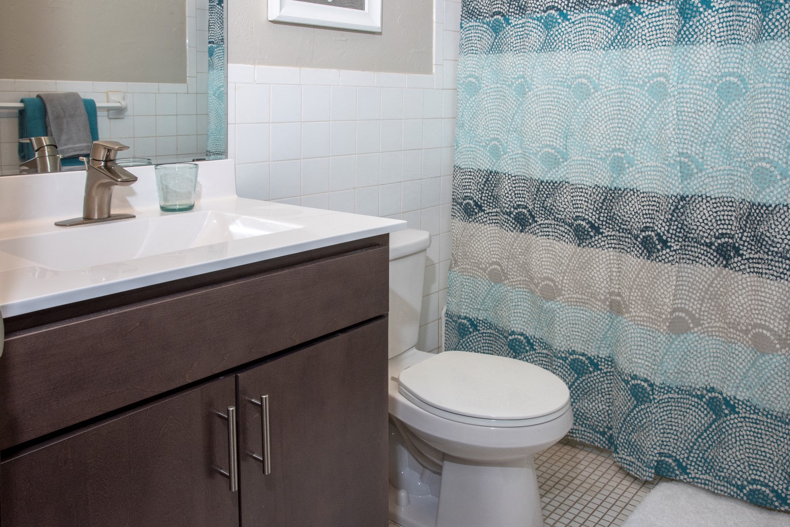 a bathroom with a toilet and a sink and a shower curtain
