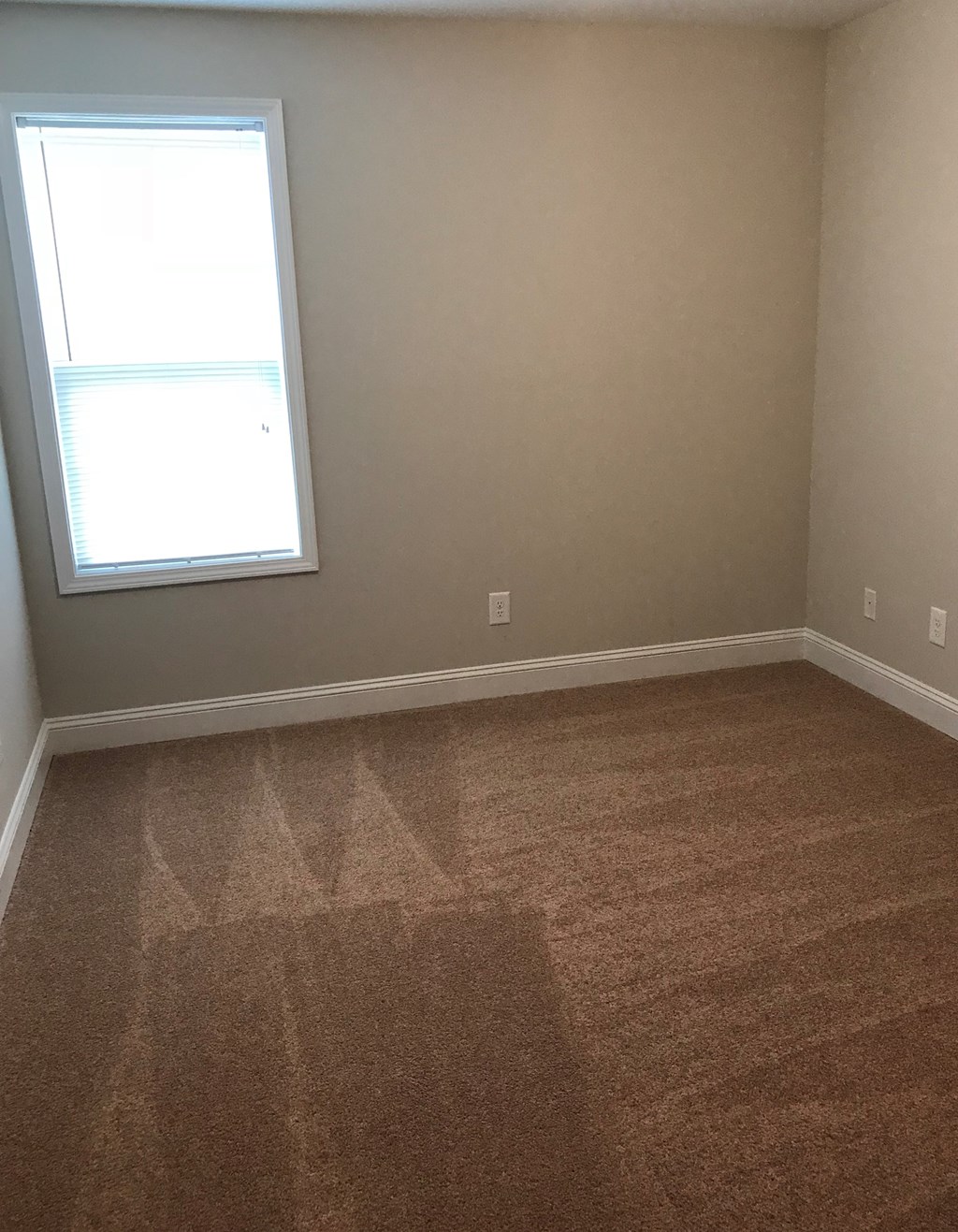 a empty room with carpet and a window