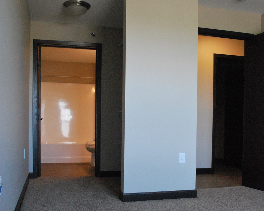 an empty room with a door open to a bathroom